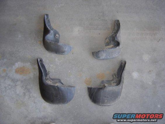 four mud flaps on a concrete surface