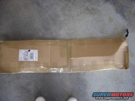 Cardboard box with shipping label on concrete floor