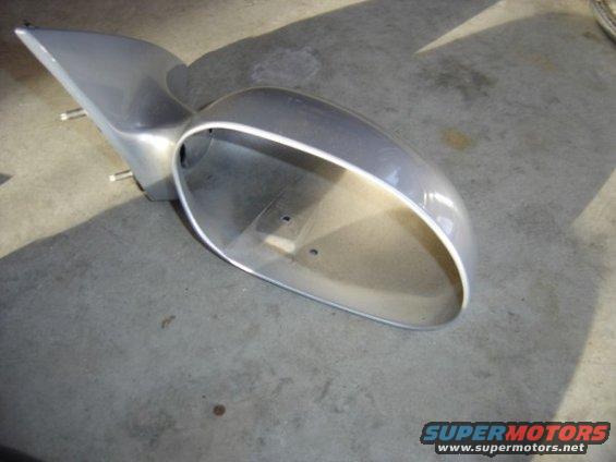 silver car side mirror housing, detached, on concrete floor