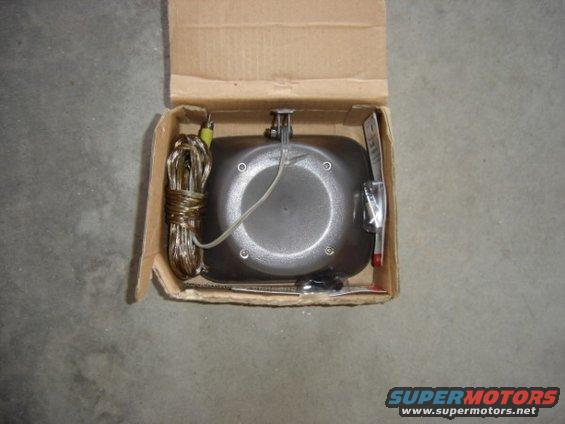 Car part in cardboard box with wires and a red-tipped probe