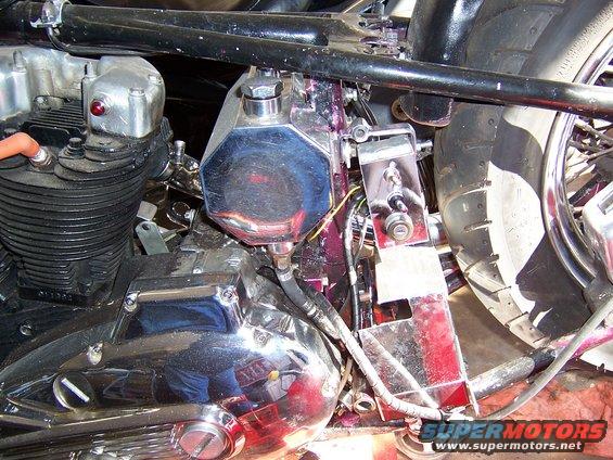Close-up of a motorcycle's engine, chrome oil tank, and rear tire