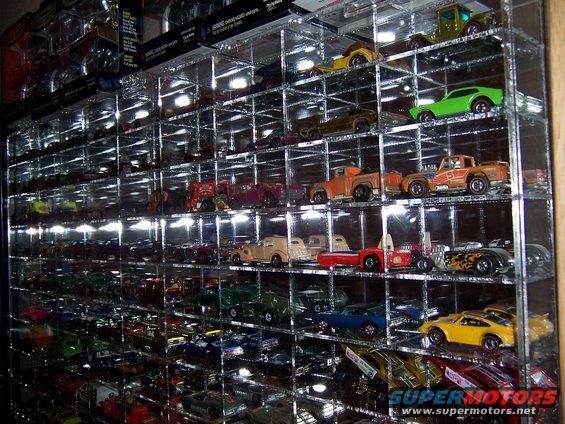 Display case filled with numerous toy cars of various colors and models