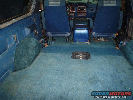 Blue carpeted interior of a vehicle with blue seats and a blue center console
