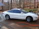 1993 Ford Probe - Side view of a white 1993 Ford Probe coupe with blue racing stripes.