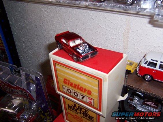 Red toy car with open hood on display box