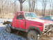 1984 Ford Bronco - This modified red pickup truck, possibly from the early 1980s, features a chopped roof and a flatbed conversion, seen in a snowy outdoor se…