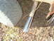 1984 Ford Bronco - Close-up of a vehicle's exhaust pipe and tire, with debris on the ground.