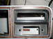 1979 Ford Bronco - Dashboard trim with wood grain accents and openings for a radio and gauges, likely from a 1979 Ford Bronco.