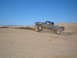 1985 Ford Ranger - A gray Ford Ranger is airborne while cresting a sand dune under a clear blue sky.