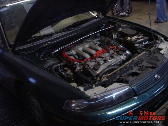 1994 Mazda 626 engine bay with hood open, showing V6 engine and red spark plug wires