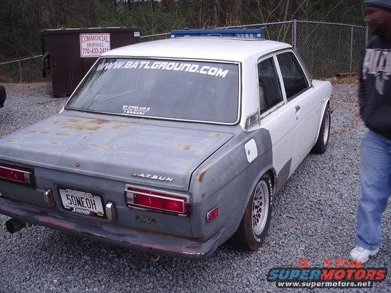 Datsun 510 sedan with primer gray rear quarter panels and white roof. License plate reads 50NEOH