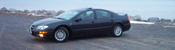 Black 1999 Chrysler 300M parked on gravel near water