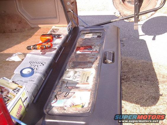 Ford Bronco tailgate interior with tools and newspaper lining
