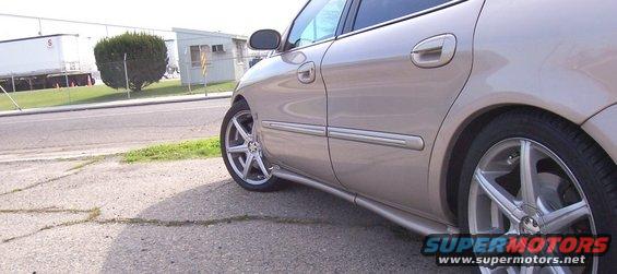 Side view of a tan 1998 Mercury Sable with aftermarket wheels