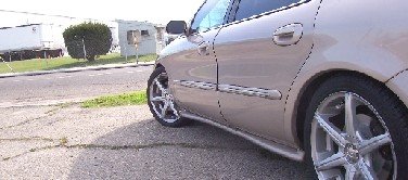 tan sedan side view, showing front wheel and door handle