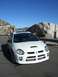 1996 Ford Probe - A white Dodge Neon SRT-4 is parked on the side of a road with a mountainous landscape in the background.