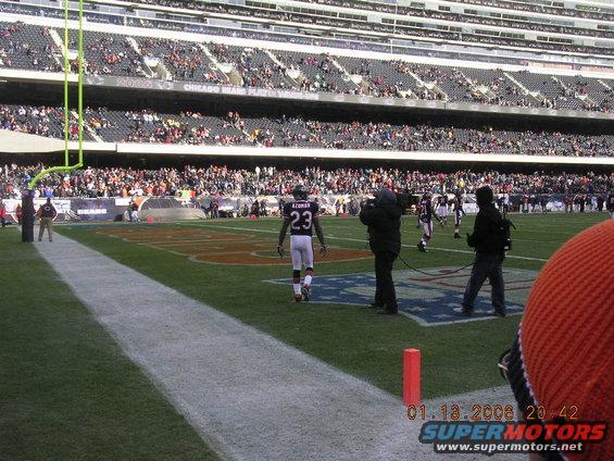 Football players on field with spectators in stadium