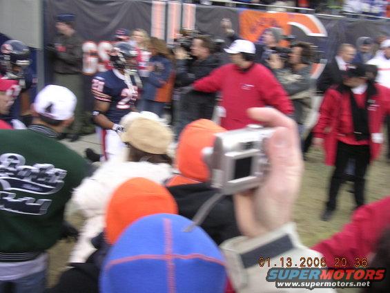 Football player with number 25 on jersey, surrounded by crowd and cameras