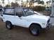 1974 Ford Bronco - This 1974 Ford Bronco features a white exterior and a black soft top, captured in a 3/4 front view.