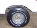 1974 Ford Bronco - A close-up of a vehicle's wheel and tire shows rust and all-terrain tread.