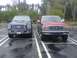 1988 Ford Bronco - Two Ford SUVs are parked side-by-side in a wet parking lot with trees in the background.