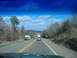 1999 Honda RANCHER - A truck tows a white trailer down a highway with trees lining the road.