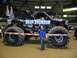 1976 Ford F-150 - A monster truck named 'Blue Thunder' is displayed with a woman posing in front of it.