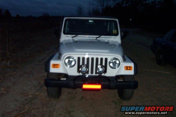 Front view of a white 2006 Jeep Wrangler with aftermarket lights