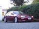 1993 Mazda MX-3 - Maroon 1993 Mazda MX-3 with aftermarket front lip and wheels, parked outdoors.