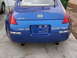 2003 Nissan 350Z - The rear of a blue Nissan 350Z is visible, with its distinctive taillights and dual exhaust pipes.