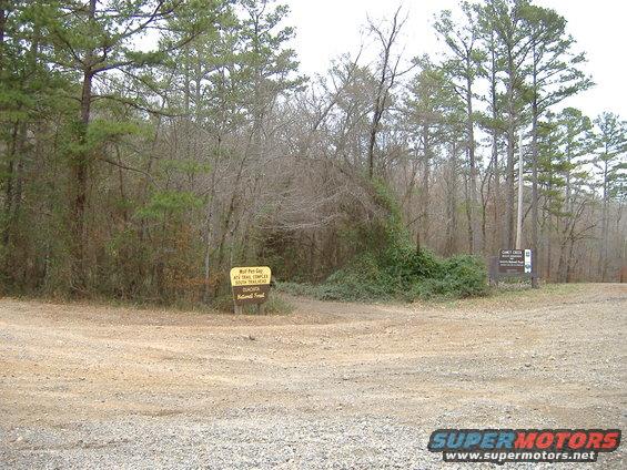 Dirt road intersection with signs for Wolf Pen Gap and Camel Creek in Ouachita National Forest