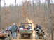 1999 Honda RANCHER - A group of ATVs and a utility vehicle are parked on a dirt road in a wooded area.