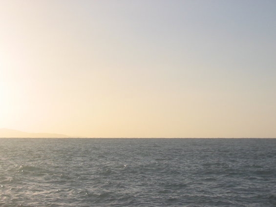 Ocean horizon under a pale yellow sky