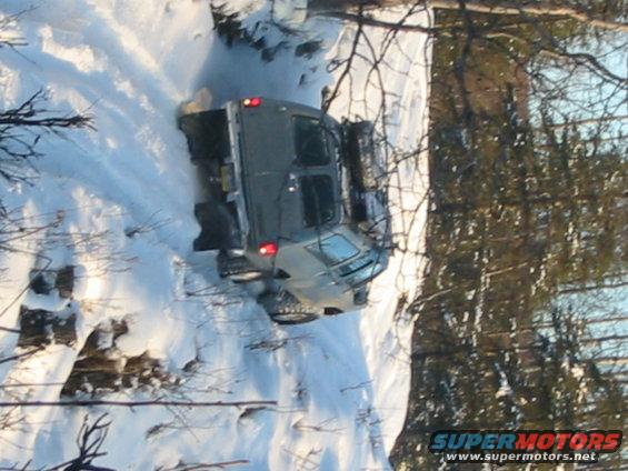 Gray 2000 Jeep TJ stuck in snow on a steep incline
