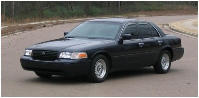 Black Ford Crown Victoria parked on a road