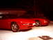 1994 Ford Probe - Two red 1994 Ford Probes are parked in the snow at night.