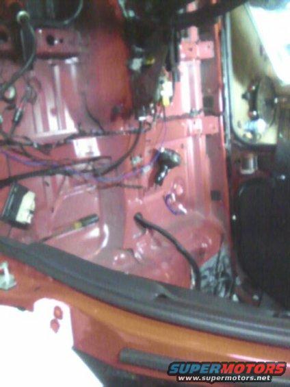 Interior view of exposed wiring harness and red metal body panels