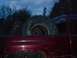 2001 Dodge 1500 - A red truck is seen from the rear in a dimly lit outdoor setting with an archway in the background.