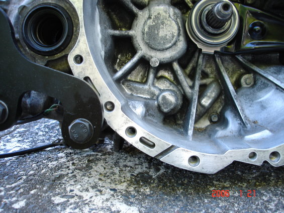 Close-up of a transmission bell housing with bolts and internal splines visible