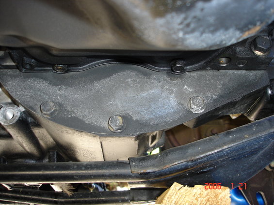 Close-up of a car's transmission housing with bolts and some grime