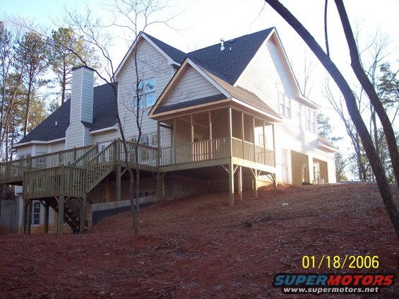 Rear view of a two-story house with a large wooden deck and screened porch. Date stamp reads 01/18/2006