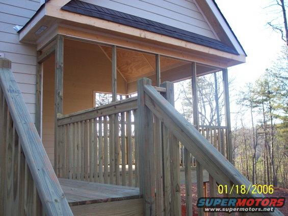 Under construction screened porch with wooden stairs and railings