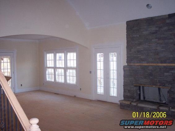 Interior of a room with a stone fireplace, French doors, and windows. A date stamp reads 01/18/2006