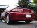 1993 Mazda MX-3 - The rear of a red Mazda MX-3 is shown, with a spoiler and dual exhaust pipes.