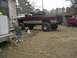 2001 Dodge 1500 - A lifted maroon 2001 Dodge 1500 pickup truck with oversized tires sits in a yard next to a house and another vehicle.