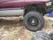 2001 Dodge 1500 - Side view of a maroon and silver 2001 Dodge 1500 pickup truck with large tires.