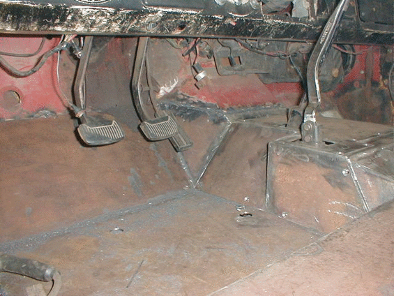 Close-up of rusty, possibly structural metal components, some with red paint remnants