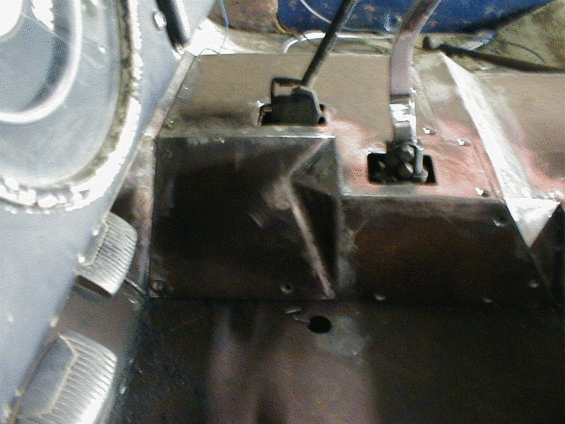 Interior view of a vehicle with two black knobs and a metal floor
