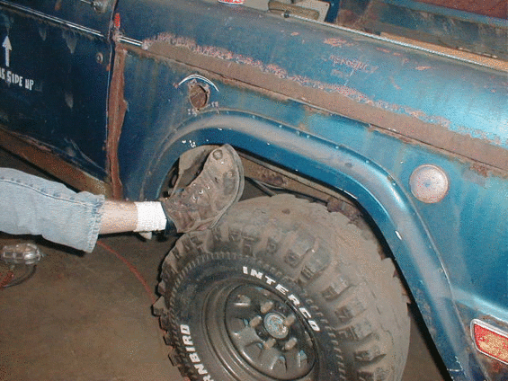 Blue SUV fender and wheel, close-up side view