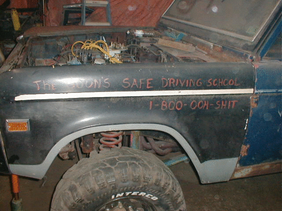 Dark blue 1968 Ford Bronco fender and door with chrome trim and visible front wheel
